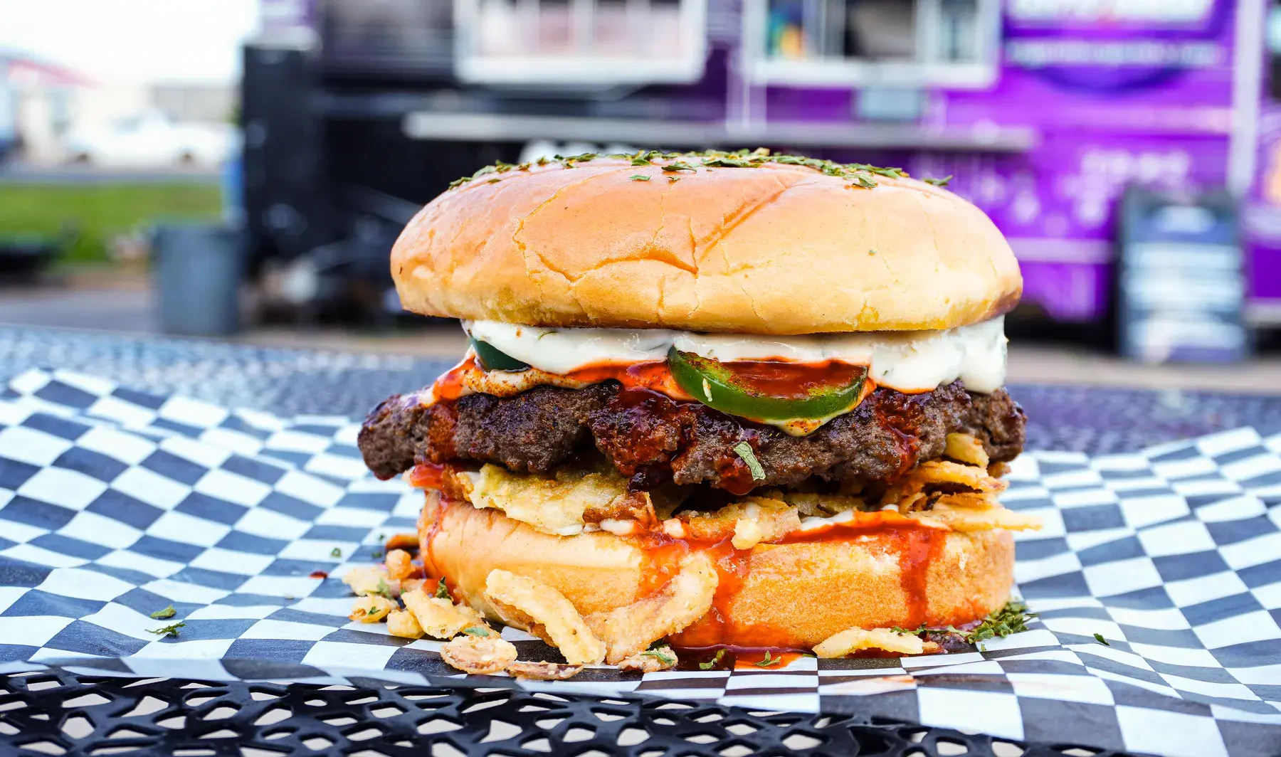 Bunqua Burger with jalapenos, fried onions, pepper jack cheese, and FOMO sauce