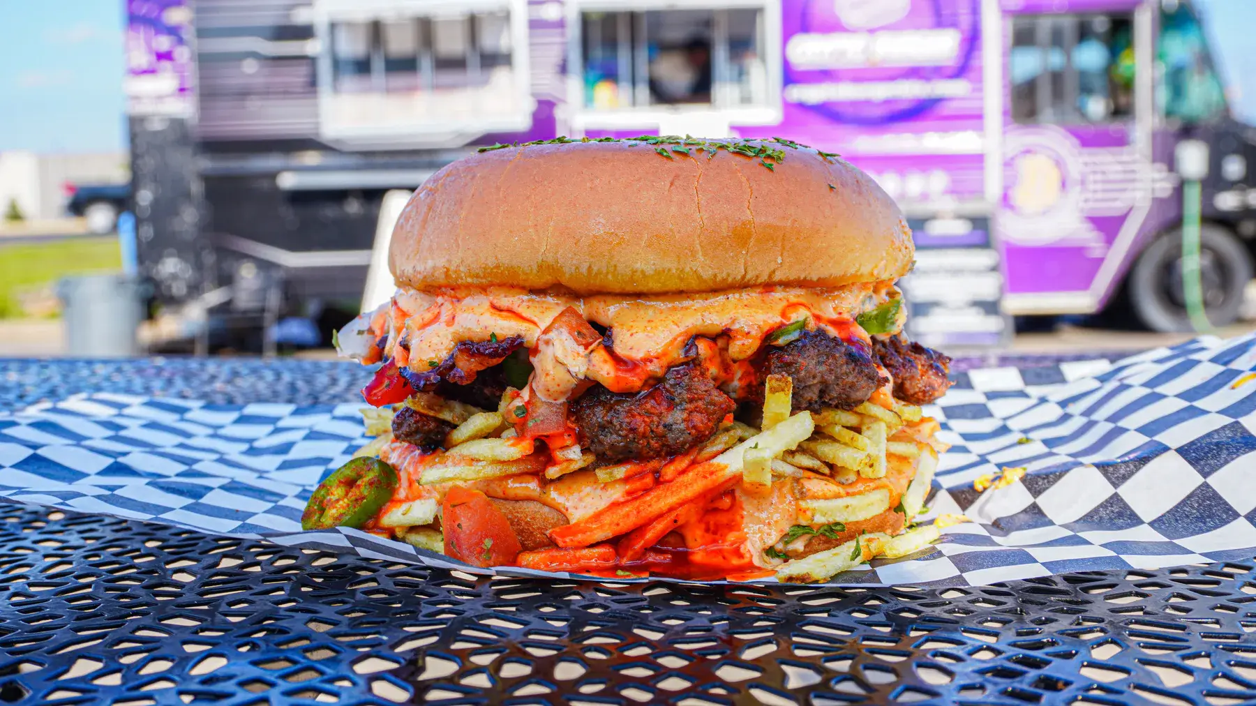 El Jefe burger with halal bacon, pico de gallo, serrano peppers, and spicy FOMO sauce