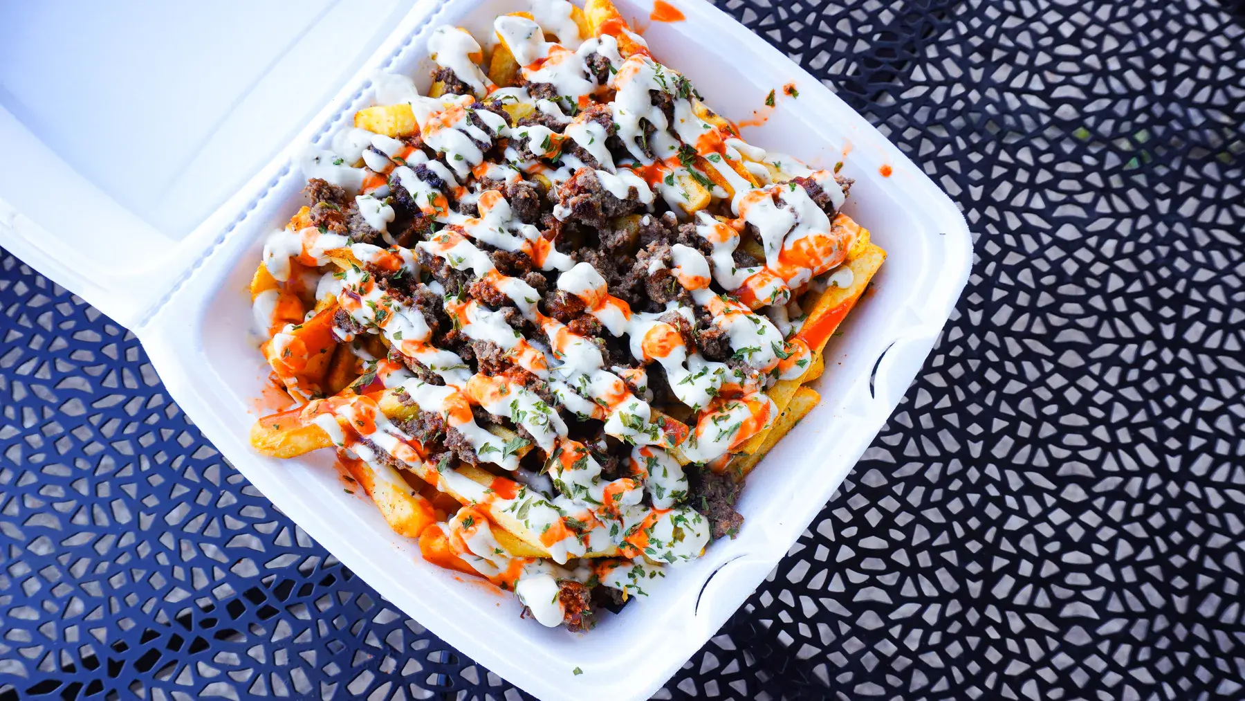 Metaverse Monster Fries loaded with chopped beef, FOMO sauce, hot sauce, and parsley